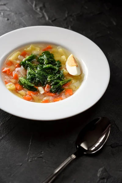 Healthy vegetarian meal with wild herbs. Homemade soup with stinging nettle and boiled egg in white plate on black background copy space — Stock Image Healthy Vegetarian Meal Wild Herbs Homemade Soup Stinging Nettle Boiled Royalty Free Stock Photos