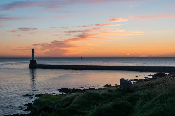 Sea wall, lighthouse and sunrise. — Stock Photo, Image