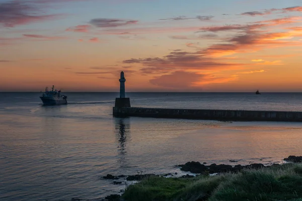 Sea wall, lighthouse, sunrise and ships. — Stock Photo, Image