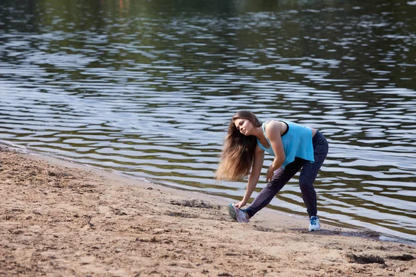 Kız sahilde spor yapıyor.