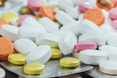 Hafif bir arka planda tedavi ve sağlık hizmetleri için tıbbi renkli haplar, kapsüller veya takviyeler.