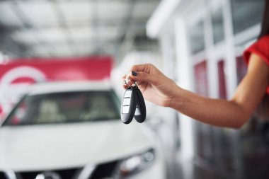 Geçen araba anahtarları. Arabanın anahtarlarını sahibi meslek satınalma araç konsepti vererek alış satış kamera boşaltmak araba bayilik salon Yöneticisi satıcısı için uzatarak bir araba satıcısı kırpılmış closeup.