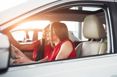 Seyahatin tadını çıkarın. Güzel genç kız ikizler ön yolcu koltuğunda oturuyor ve kamerada poz verirken gülümsüyorlar..