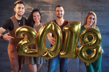 Yeni yıl partisinde eğlenen iki güzel genç çift, 2018 numaralı kartonu taşıyorlar..