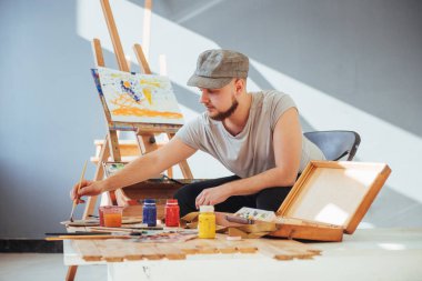 Stüdyoda resim yapan bir sanatçı.