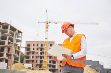 mimari ve ev yenileme kavramı - blueprint Fabrikası ile eldiven ve kask içinde adam.