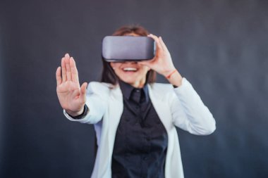 Stüdyoda siyah bir arka plan üzerinde Mutlu kadın Vr-gözlük sanal gerçeklik kulaklık kullanma deneyimi alır