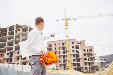 mimari ve ev yenileme kavramı - blueprint Fabrikası ile eldiven ve kask içinde adam.