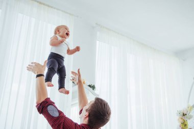 Father throwing hand high air joyful daughter. The concept of a friendly family.