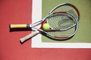 Tenis raketi ve yeni boyanmış tenis kortunda yeni bir tenis topu..