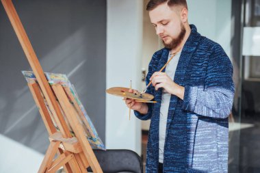 Stüdyoda resim yapan bir sanatçı.