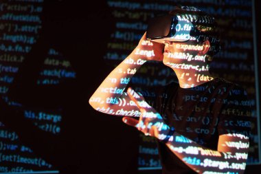 Kafkasyalı bir adam ve Sanal gerçeklik kulaklığının çifte pozlandırılması muhtemelen kod satırları olan güvenli bir ağ ya da sunucuya şifreyi kıran bir oyuncu ya da hackerdır.