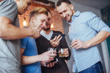 Neşeli eski arkadaşlar birbirleriyle iletişim kurarlar ve barda bir bardak viski içerler. Eğlence ve yaşam tarzı kavramı. Eşi bar masasındaki insanlarla bağlantı kurdu.