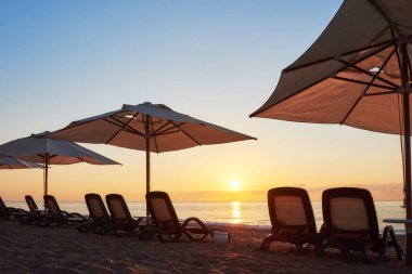 Kumsaldaki kumlu sahilin manzarası. Deniz ve dağlara karşı güneş yatakları ve şemsiyeler açık. Amara Dolce Vita Luxury Oteli. Tatil köyü. Tekirova-Kemer. Türkiye