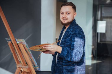 Stüdyoda resim yapan bir sanatçı.