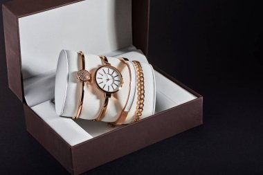 Beyaz bir arka planda altın kadın kol saati.