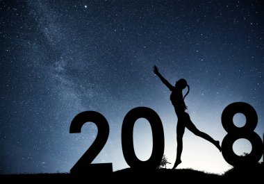 Siluet genç kız. Yeni yılın kutlu olsun. Samanyolu Galaksisi 'nin arkaplanı parlak bir yıldızla karanlık bir gökyüzü tonuyla.