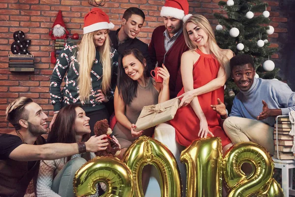 Foto com amigos. O grupo de jovens alegres faz uma foto festiva perto da árvore de Natal. Feliz Ano Novo 2018 para você! Conceito de entretenimento e estilo de vida — Fotografia de Stock