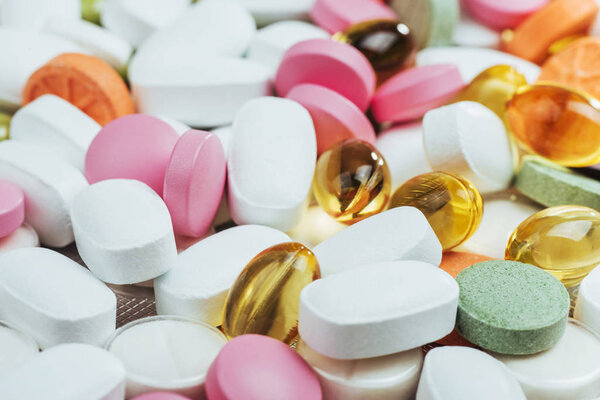 Medical colorful pills, capsules or supplements for the treatment and health care on a light background.