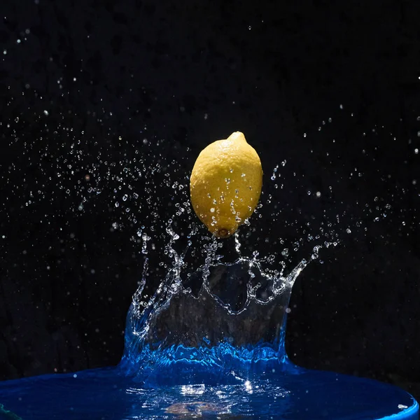Ζουμερό Κίτρινο Λεμόνι Πέφτει Στο Νερό Μαύρο Φόντο — Φωτογραφία Αρχείου