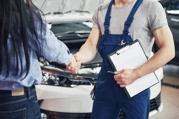 汽车修理工和女顾客就修理汽车达成协议 — 图库照片