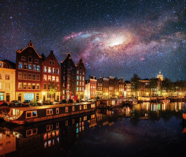 Beautiful night in Amsterdam. Night illumination of buildings and boats near the water in the canal. Courtesy of NASA.