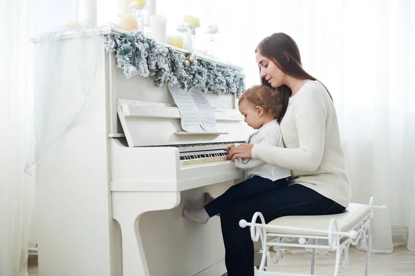 後ろから見てください母と娘で遊んで白いピアノ — ストック写真