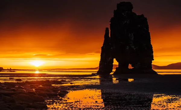 アイスランドの北海岸の海にある壮大な岩です 伝説によると それは精製されたトロールです この写真では Hvitserkurは真夜中の日没後に海の水に反映されます — ストック写真