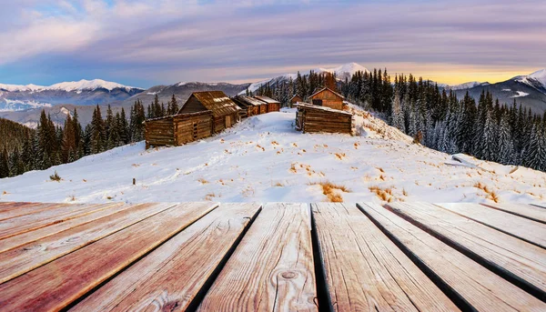 雪の森と木の小屋とみすぼらしいテーブルがある冬の山の風景 — ストック写真