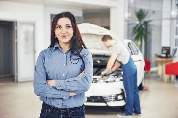 車のガレージで機械的なサービスを受ける女性 整備士は車のフードの下で働く — ストック写真