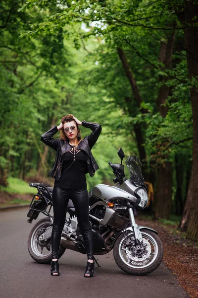 魅力的なセクシー女の子服を着た革のポーズ近くにAスポーツバイク外 — ストック写真
