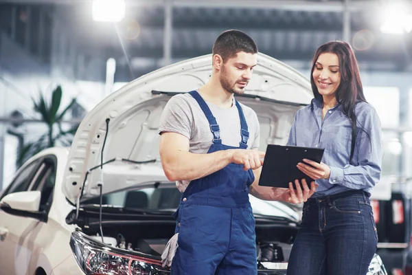 Ein Mechaniker Und Eine Kundin Diskutieren Reparaturen Ihrem Fahrzeug — Stockfoto