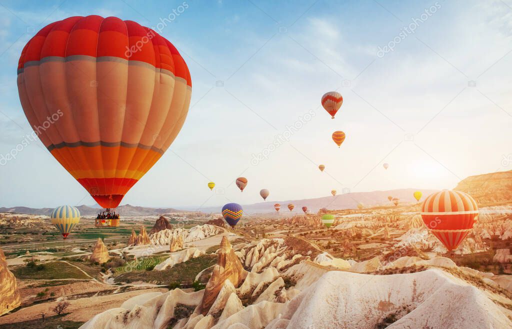Hot air balloon flying over rock landscape at Turkey. Cappadocia with its valley, ravine, hills, located between the volcanic mountains in Goreme National Park.