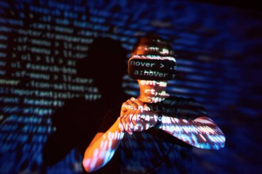 Kafkasyalı bir adam ve Sanal gerçeklik kulaklığının çifte pozlandırılması muhtemelen kod satırları olan güvenli bir ağ ya da sunucuya şifreyi kıran bir oyuncu ya da hackerdır.