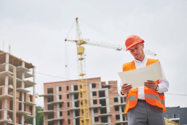 mimari ve ev yenileme kavramı - blueprint Fabrikası ile eldiven ve kask içinde adam.