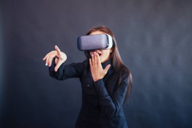 Stüdyoda siyah bir arka plan üzerinde Mutlu kadın Vr-gözlük sanal gerçeklik kulaklık kullanma deneyimi alır