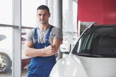 İngiliz anahtarı olan bir araba tamircisi. Otomatik tamir garajı.