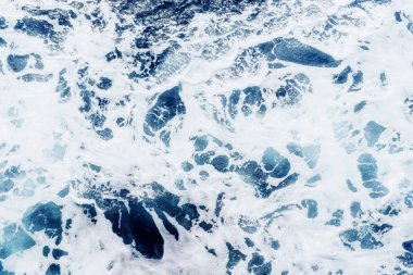 Güneşli bir günde mavi suyla Atlantik Okyanusu. Dalgalar, köpük ve deniz yolculuğunun yol açtığı uyanma.