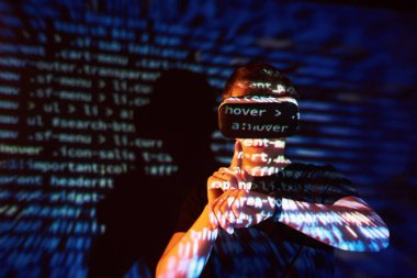 Kafkasyalı bir adam ve Sanal gerçeklik kulaklığının çifte pozlandırılması muhtemelen kod satırları olan güvenli bir ağ ya da sunucuya şifreyi kıran bir oyuncu ya da hackerdır.