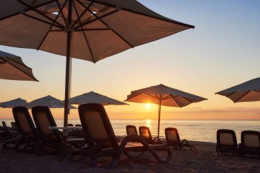Kumsaldaki kumlu sahilin manzarası. Deniz ve dağlara karşı güneş yatakları ve şemsiyeler açık. Amara Dolce Vita Luxury Oteli. Tatil köyü. Tekirova-Kemer. Türkiye