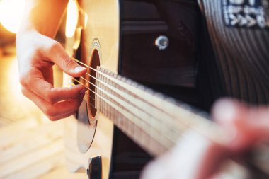 Gitarist gitar üzerinde ahşap arka plan çalış, yakın çekim.