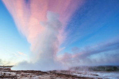 Strokkur şofben Erüpsiyonu İzlanda '. Harika renkler steam üzerinden Parlatıcı. Mavi gökyüzünde güzel pembe bulutlar.