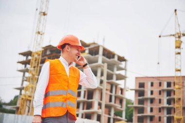 Koruyucu Kask ayakta açık arka bina dağlar giymiş genç mimar.