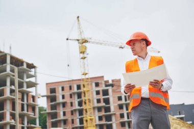 mimari ve ev yenileme kavramı - blueprint Fabrikası ile eldiven ve kask içinde adam.