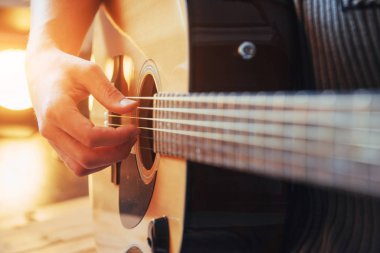 Gitarist gitar üzerinde ahşap arka plan çalış, yakın çekim.