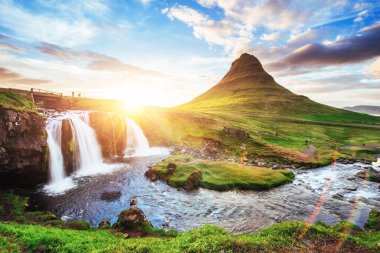 The picturesque sunset over landscapes and waterfalls. Kirkjufell mountain, Iceland. clipart