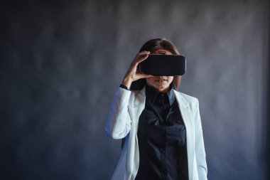 Stüdyoda siyah bir arka plan üzerinde Mutlu kadın Vr-gözlük sanal gerçeklik kulaklık kullanma deneyimi alır