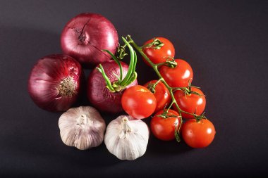 Domates, soğan ve sarımsak siyah arka planda izole edilir.