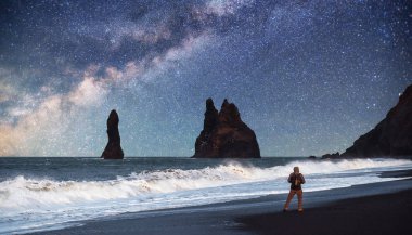 Rock Troll Parmakları. Reynisdrangar uçurumları. Siyah kum plajı. İzlanda. Fantastik yıldızlı gökyüzü ve Samanyolu.