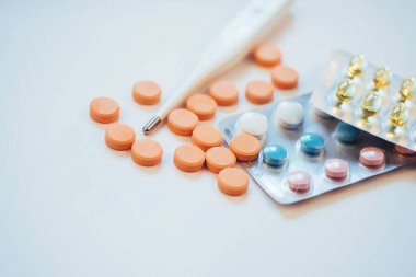 Grip. Yüksek sıcaklık ve ışık arka plan üzerinde çok hap ile termometre.